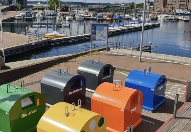 Gekleurde afvalbakken van MCB in de haven van Almere